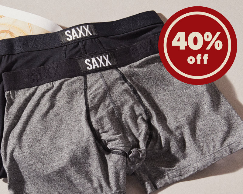 A closeup of black and grey SAXX trunks, next to a closeup of a man wearing black and grey striped SAXX Boxer Briefs.