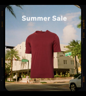 A snapshot of a city street corner with palm trees and clear blue skies with a red SAXX crew neck tee shirt overlaying the image along with the text "Summer Sale".