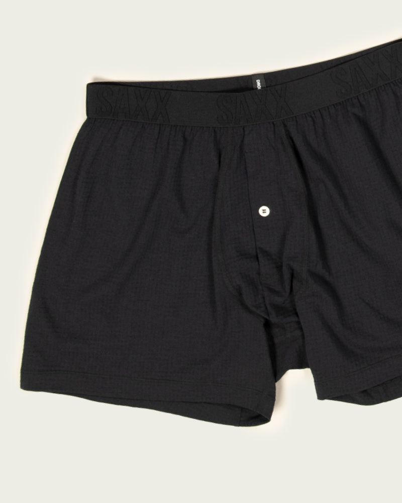 Black SAXX Loose Fit Boxer Briefs laid out flat over white backdrop.