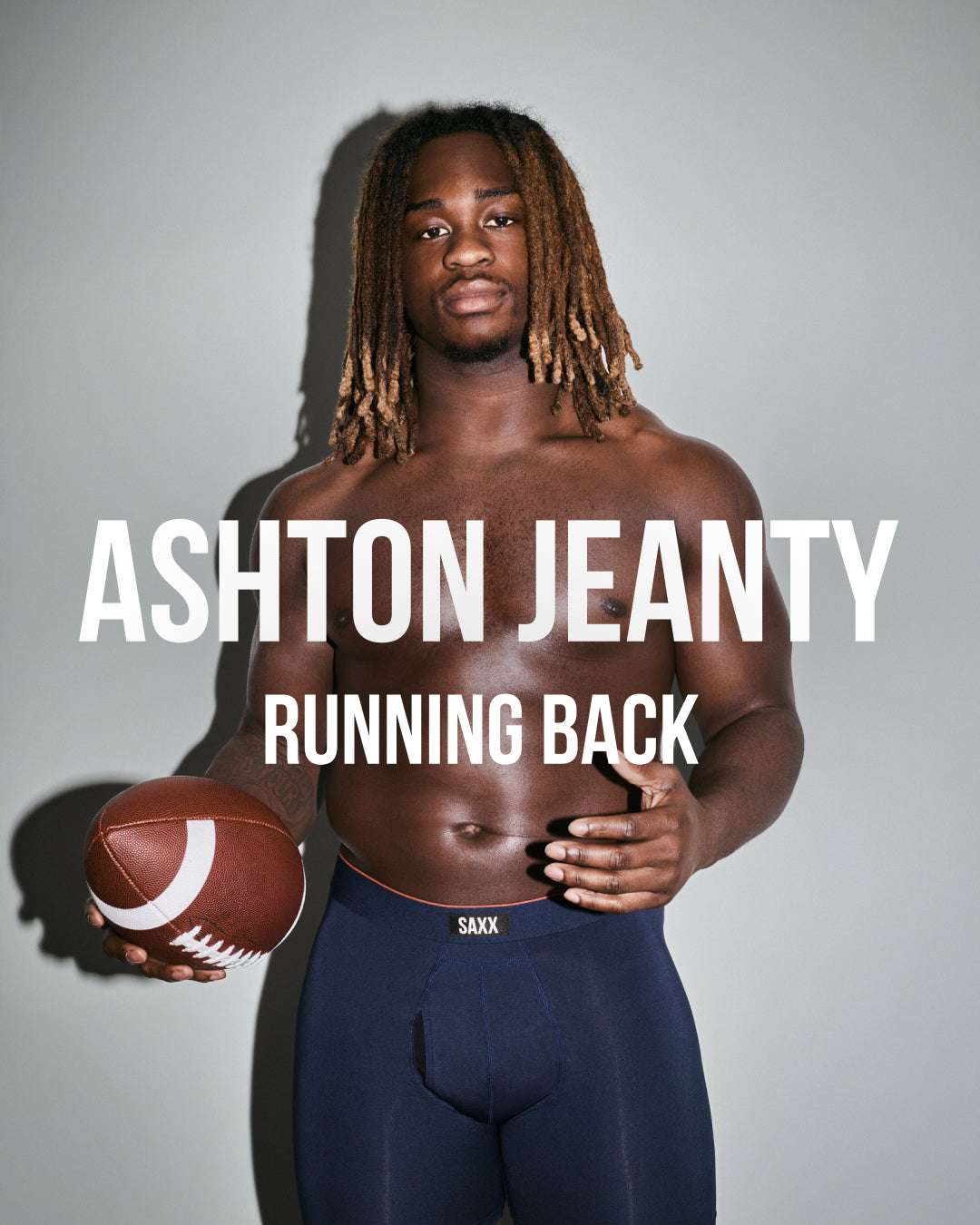 Man in navy blue SAXX Boxer Briefs holding football against neutral background, with the text ‘Ashton Jeanty Running Back’.